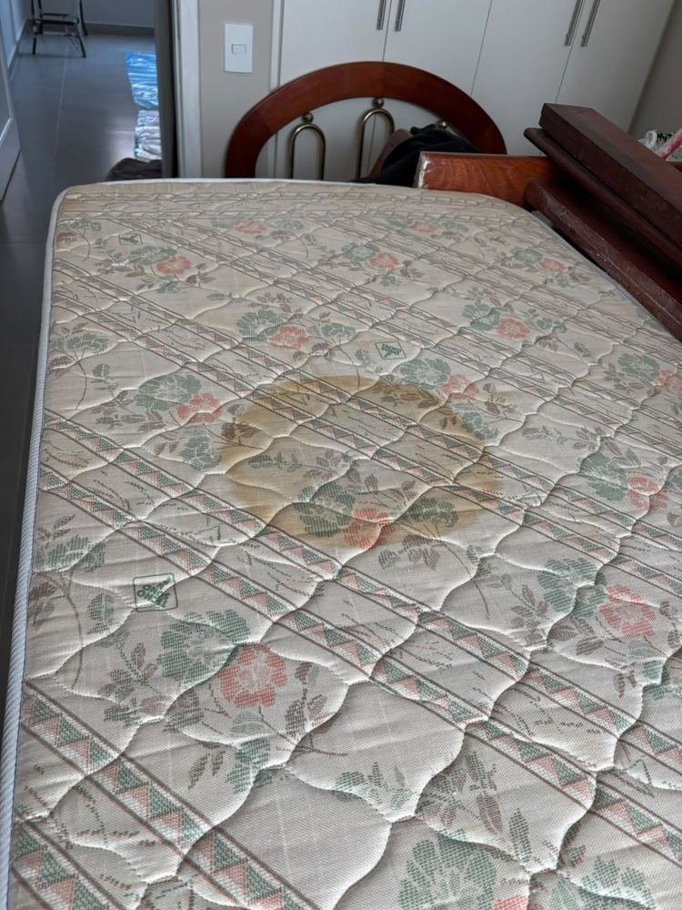 Colchão de solteiro com mancha amarela grande no centro, antes da limpeza com a extratora